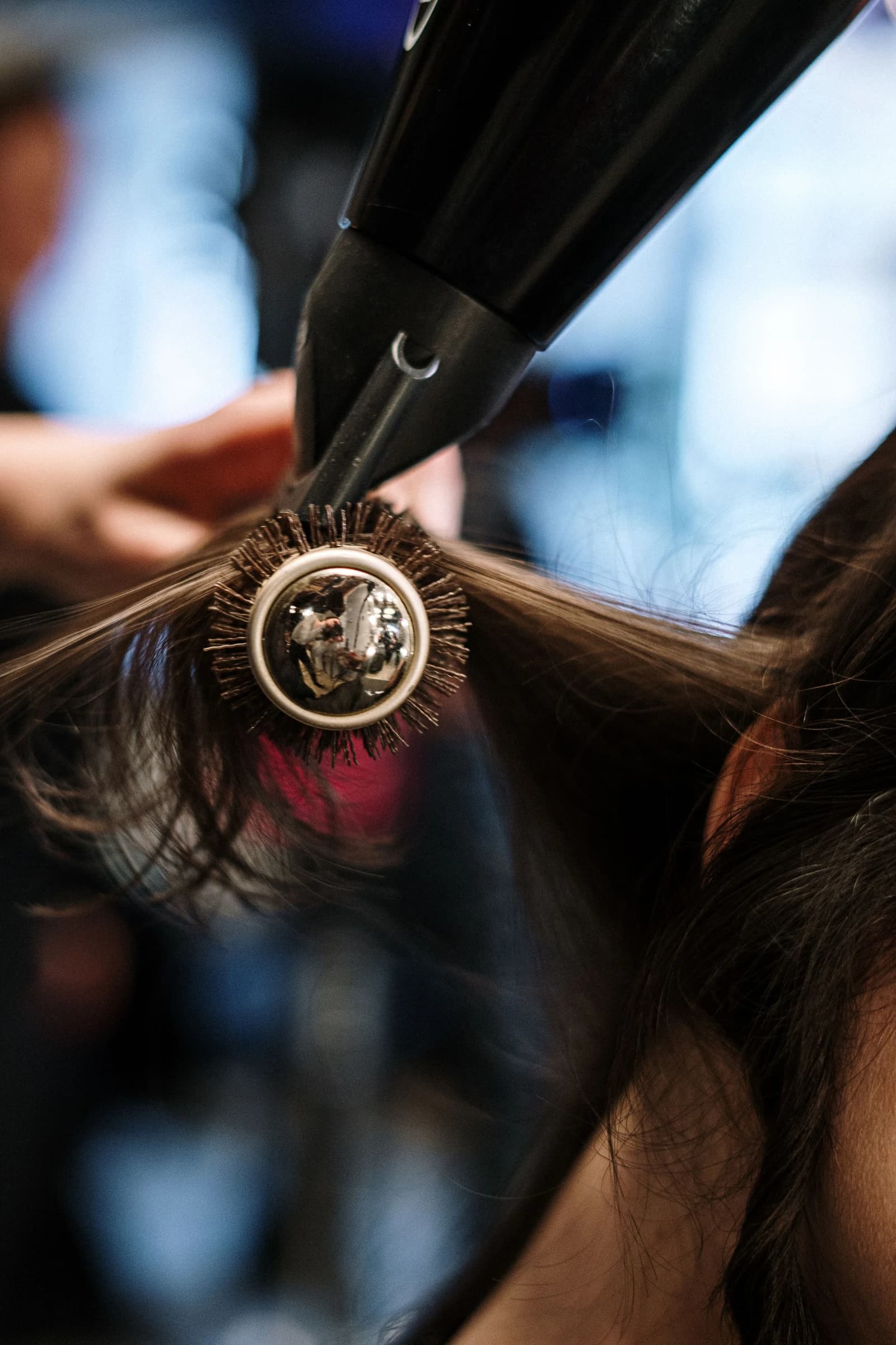 Stylist blow-drying a client’s hair in a salon