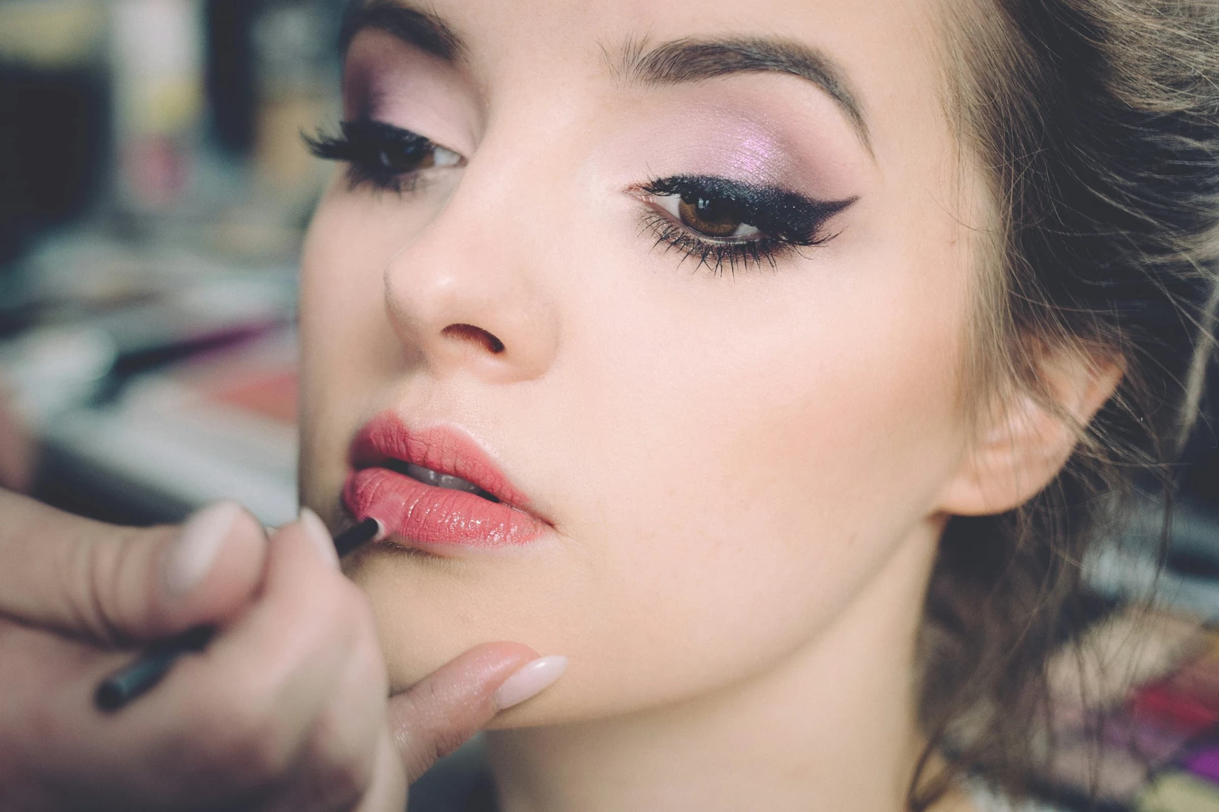Makeup artist applying lipstick for a client